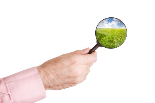 hand of man with loupe isolated on white background and summer landscape( from my image)