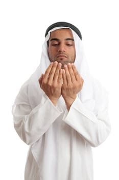 An arab middle eastern man dressed in traditional rob and headdress with open hands praying.