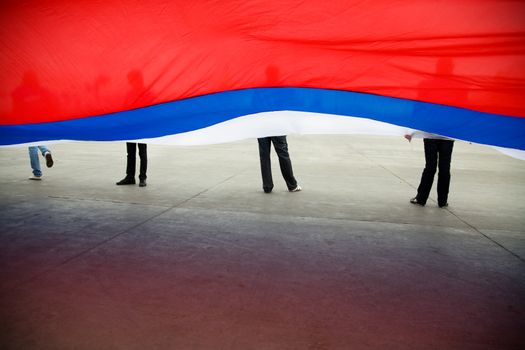 large russian flag with legs of young people, selective focus