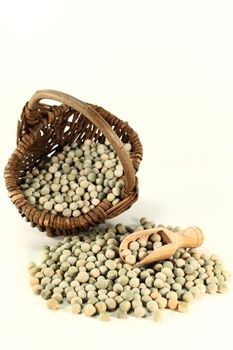 dried green peas in a basket on a white background