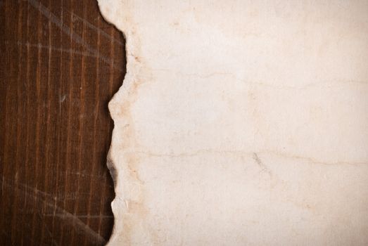 paper with  torn edges on wooden texture, focus point on center