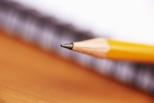 yellow pencil, selective focus on writing part (center of photo)
