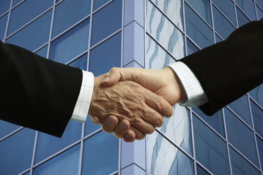 businessmen handshake on modern building background, selective focus