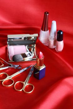 Still life with cosmetics set on red silk
