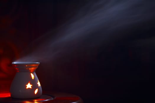 Smoking oil incense on a wooden background