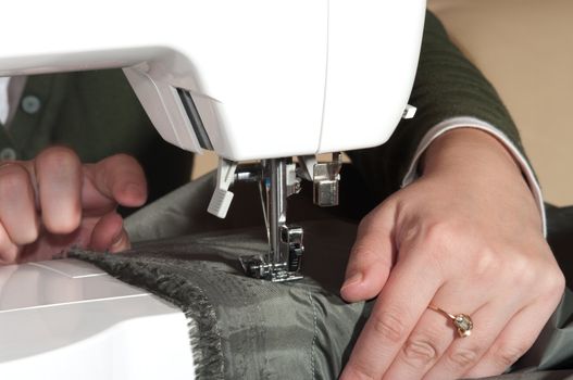 Female hands sewing on a machine.