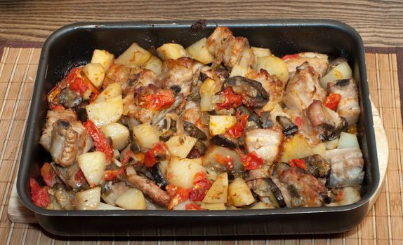 Meat ragout with vegetables on a baking sheet.