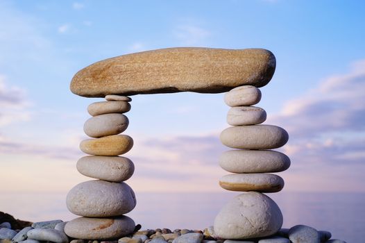 Long horizontal stone is between a pebble piles