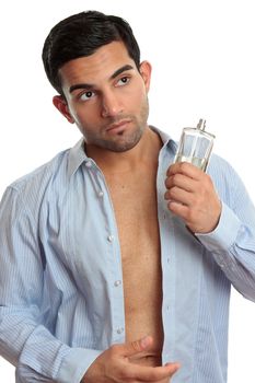 A man holding a bottle of cologne while getting dressed