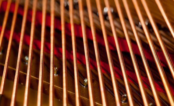 Close up image of interior of grand piano showing strings and structure