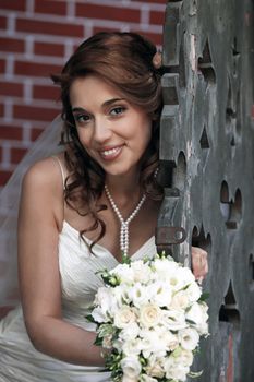 The beautiful bride with bouquet in park