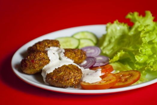 Traditional turkish meat ball served on white plate with vegetable mix