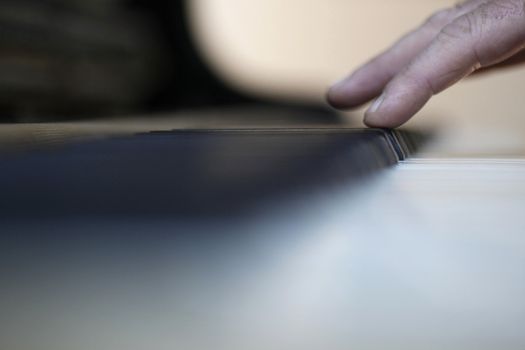 male fingers barely touching keys of piano