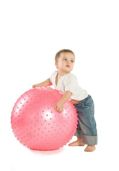 A little boy with a big pink fitness ball