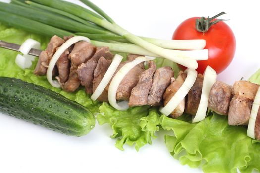Appetizing shish kebab with tomatoes and greens
