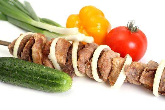 Appetizing shish kebab with tomatoes and greens