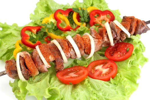 Appetizing shish kebab with tomatoes and greens