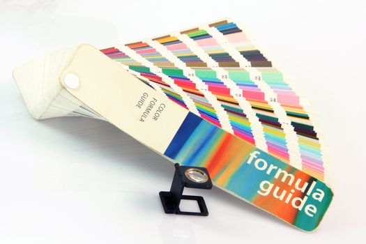 pantone colors formula guide with graphic art loupe lense isolated on white background