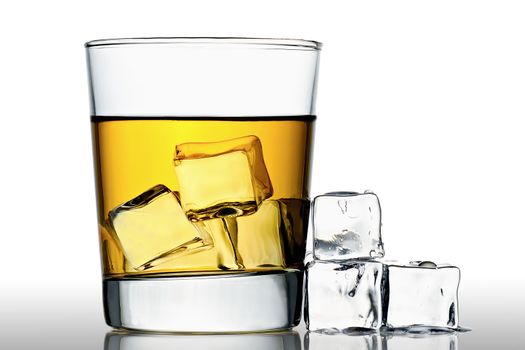 glass of whisky on the rocks with ice cubes next to, isolated on white