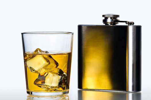 glass of whisky on the rocks  and stainless flask on white background