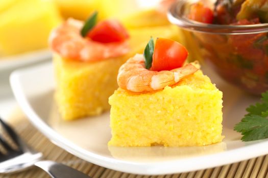 Polenta slices with shrimp and cherry tomato accompanied by hogao, a Colombian sauce made of tomato, onion and cilantro (Selective Focus, Focus on the front of the shrimp) 