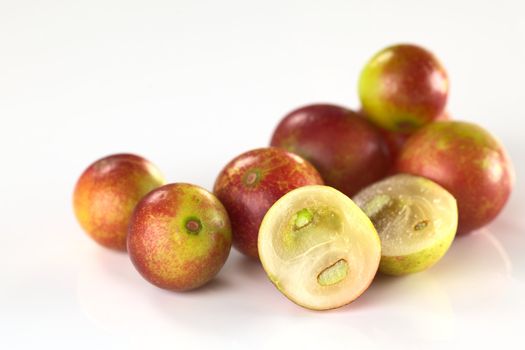 Camu camu berry fruits (lat. Myrciaria dubia) which are grown in the Amazon region and have a very high Vitamin C content (Selective Focus, Focus on the half camu camu in the front and the the complete berry to the left of it)