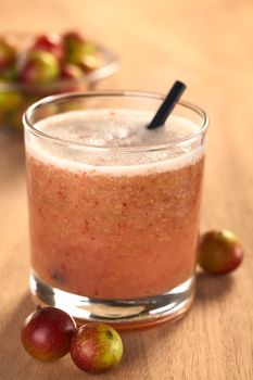 Juice out of Camu camu berry fruits (lat. Myrciaria dubia) which are grown in the Amazon region and have a very high Vitamin C content (Selective Focus, Focus on the front rim of the glass)