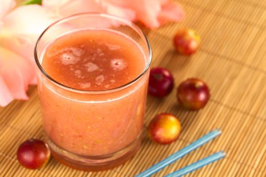 Juice out of Camu camu berry fruits (lat. Myrciaria dubia) which are grown in the Amazon region and have a very high Vitamin C content (Selective Focus, Focus on the front rim of the glass)