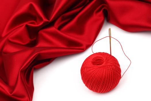 red satin and thread isolated on white