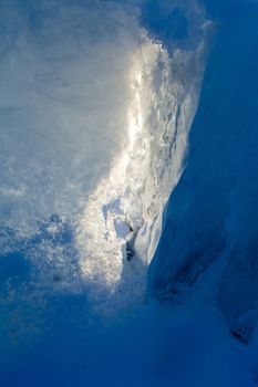 Ice forming a cave-like structure beautifully illuminated by sunlight.