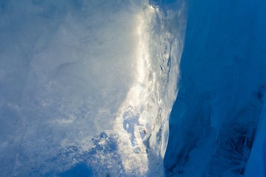 Ice forming a cave-like structure beautifully illuminated by sunlight.