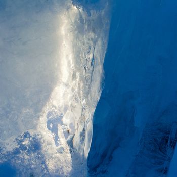 Ice forming a cave-like structure beautifully illuminated by sunlight.