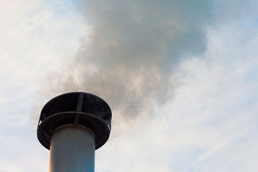 Smoking chimney of wood heated family home.