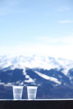 water in cup mountains on background