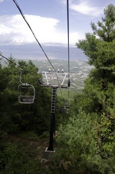 A chairlift going up a mountain pass in summer