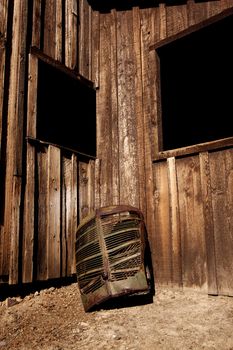 A rusty old truck grill against a barn.