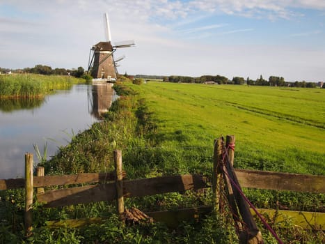 Landscape in Holland with windmills and canal.