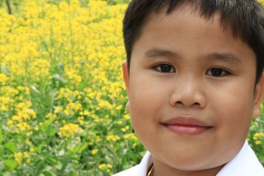 Young asian kid portraiture with yellow background flowers.
