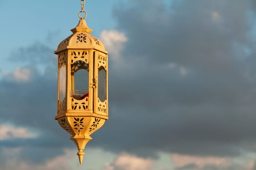 Beautiful hand crafted old vintage lantern over the blue sky background