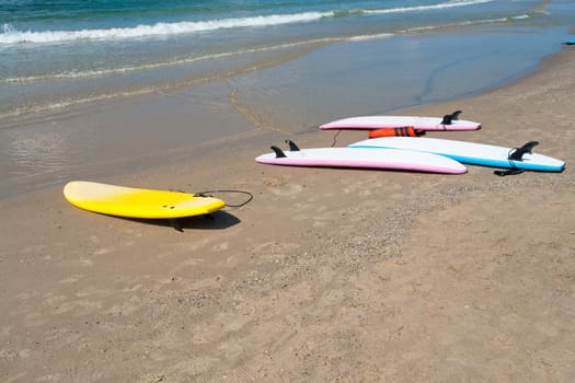 Colorfull surf boards on a  sandy beach ready for extreme action sport