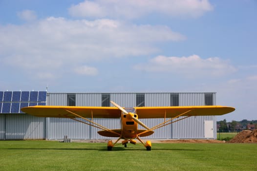 Small yellow airplane on a small airstrip