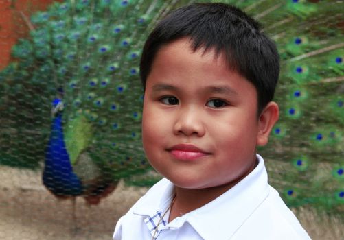 A boy portraiture and a peacock background.