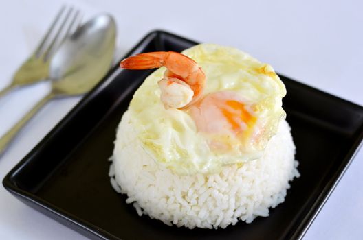 a delicious  fried egg and prawn  on steamed rice
