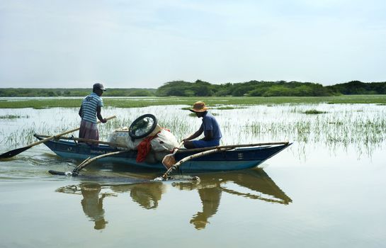 Bentota, Sri Lanka - 13, 2001: Two Sri Lankan men  floating in  the boat  by the small river.