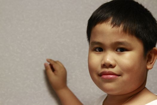 Young filipino boy with hand in the backgound.