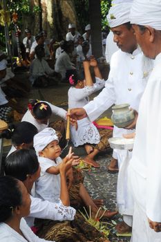 Ubud, Bali island, Indonesia - April, 06, 2011: Unidentified local people wearing in traditional indonesian clothes take part in Buda Wage Kelawu ceremony at Hindu temple.