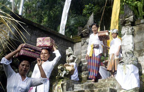 Ubud, Bali island, Indonesia - April, 06, 2011: Unidentified local woman wearing in traditional indonesian clothes take part in Buda Wage Kelawu ceremony at Hindu temple.