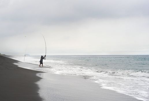 Bali, Indonesia - April 8, 2011: Fisherman catching fish on the ocean beach