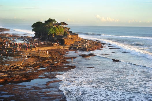 Tanah Lot is a rock formation off the Indonesian island of Bali. It is home of a pilgrimage temple, the Pura Tanah Lot (literally "Tanah Lot temple") and a popular tourist and cultural icon for photography and general exoticism