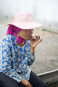 Probolingo, Indonesia - April 24,2011: Unidentified indonesian woman smoking  cigarette. Smoking in Indonesia is a common practice, as over 165 million people smoke in Indonesia. Of Indonesian people, 63% of men and 5% of women reported as smokers, a total of 34% of the population.